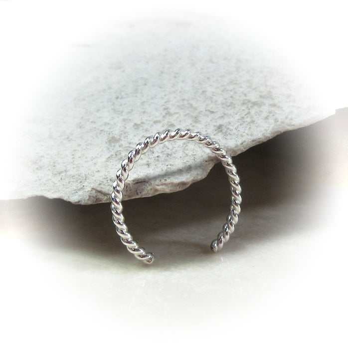 silver twisted ring against a rock