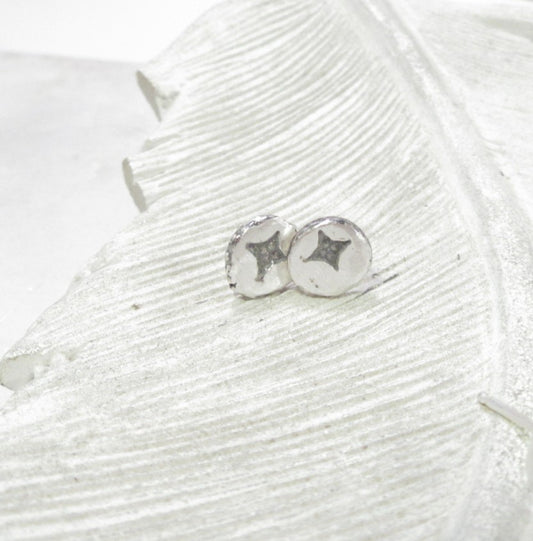 pair of post earrings for men on white background with spiritual symbols