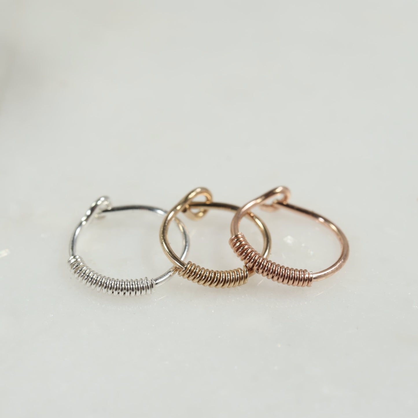 silver, gold and pink gold wrapped hoop on a white background