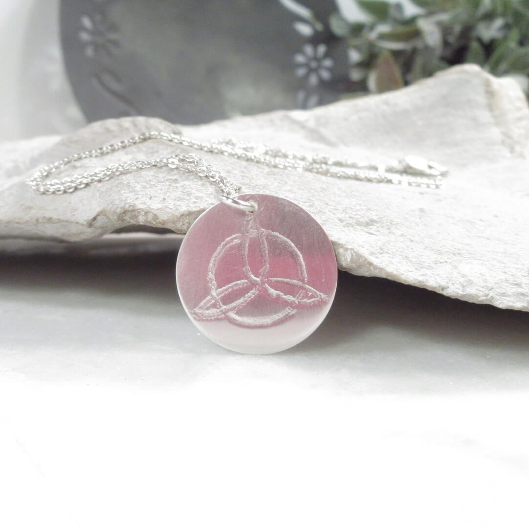 Symbol pendant with a Celtic knot design on a white surface