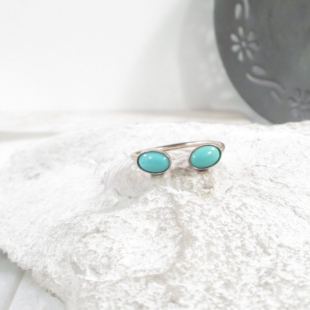 Turquoise ring on a white textured surface with a blurred background