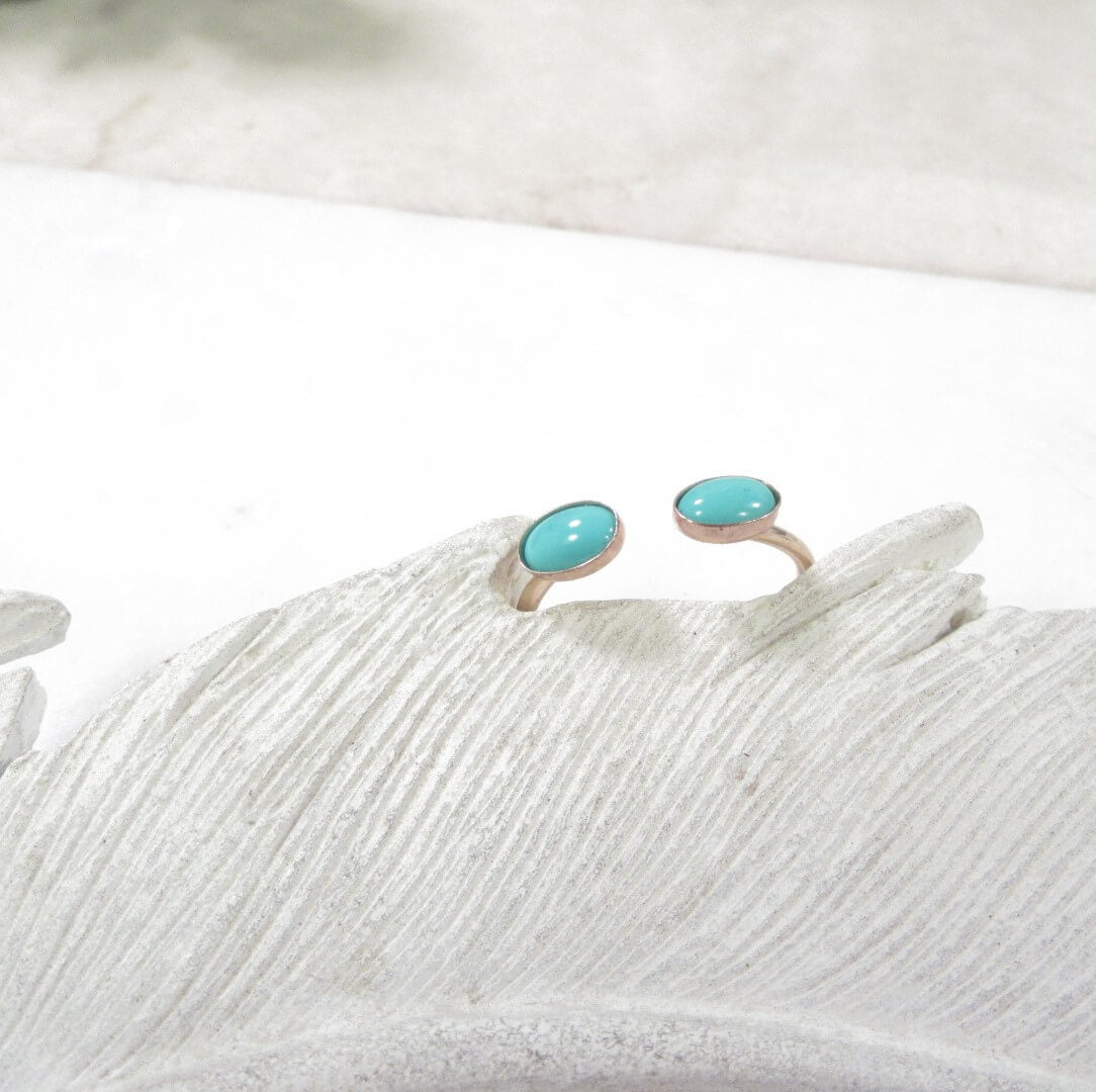 Top with turquoise stones on a textured white surface