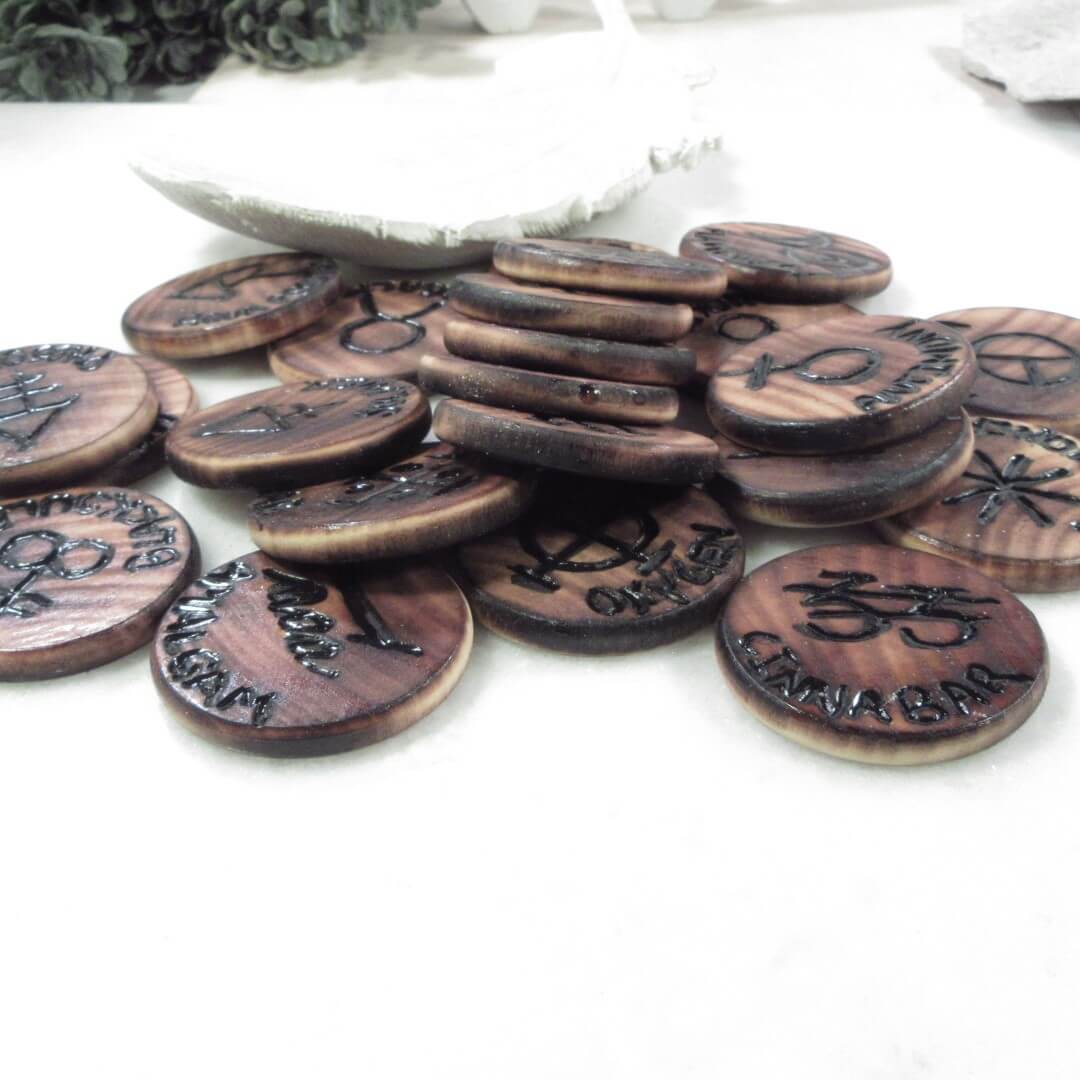 Alchemy Too engraved symbols on a white surface