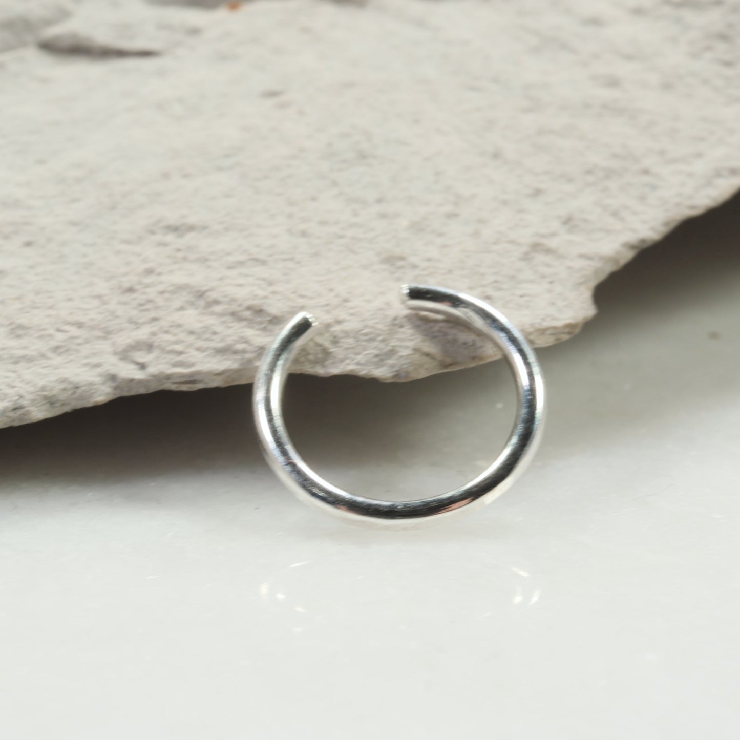 Silver nose ring on a stone surface