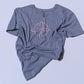 Gray t-shirt with a pink flower design on a light blue background