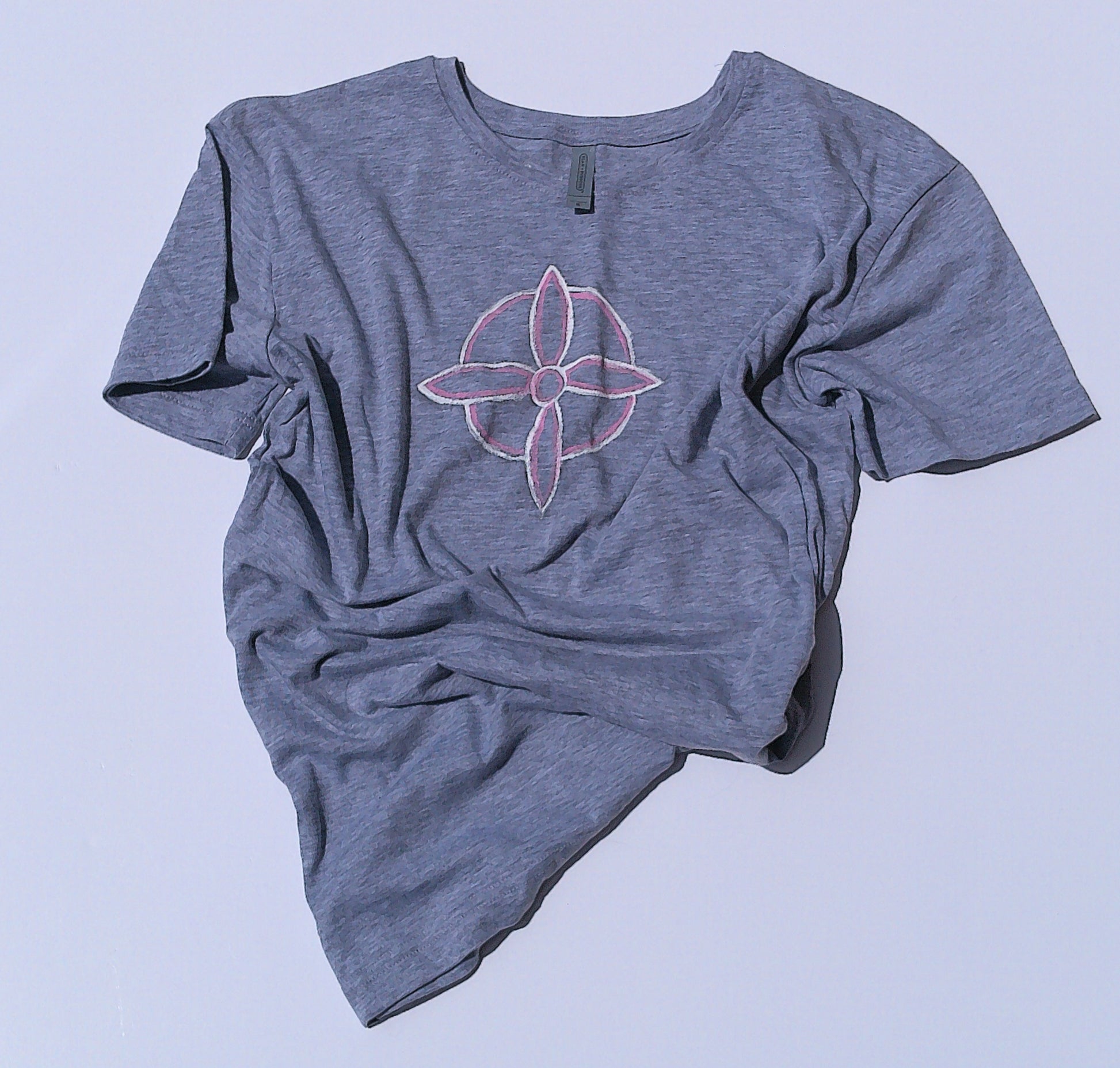Gray t-shirt with a pink flower design on a light blue background