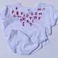 White t-shirt with red runes on a light gray background