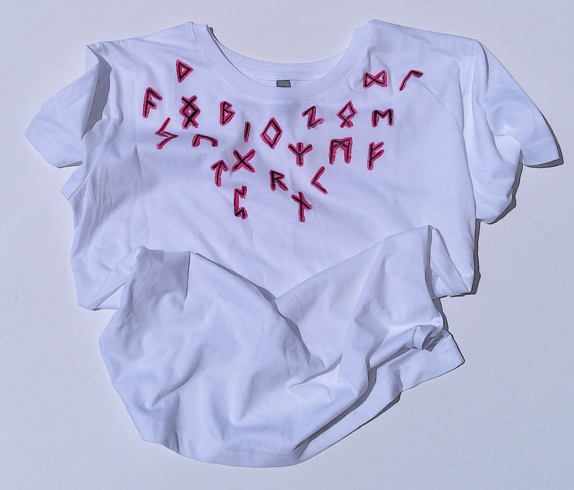 White t-shirt with red runes on a light gray background
