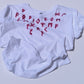 White t-shirt with red rune symbols on a light gray background