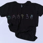 Black t-shirt with colorful symbols on a light blue background