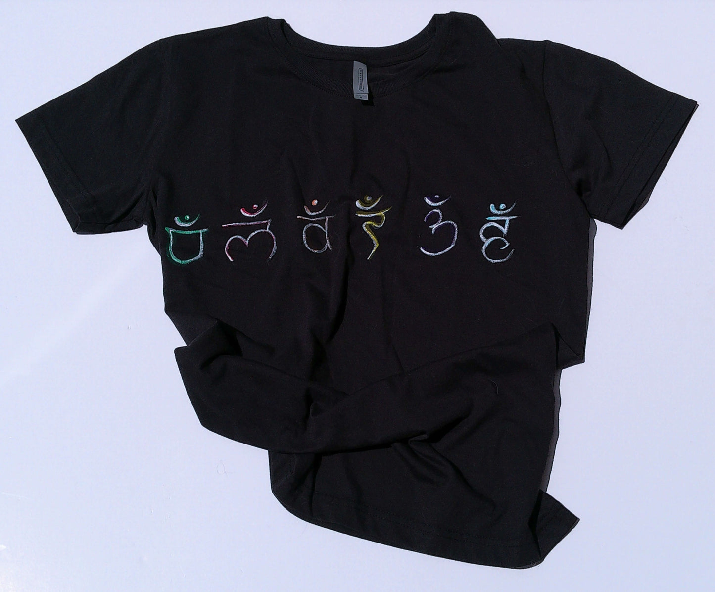 Black t-shirt with colorful symbols on a light blue background