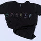 Black t-shirt with colorful symbols on a light blue background