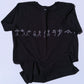 Black t shirt with white yoga designs on a light gray background