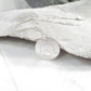 Silver necklace with a round pendant on a stone background