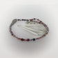 Multicolored beaded pendulum with a crystal on a white background