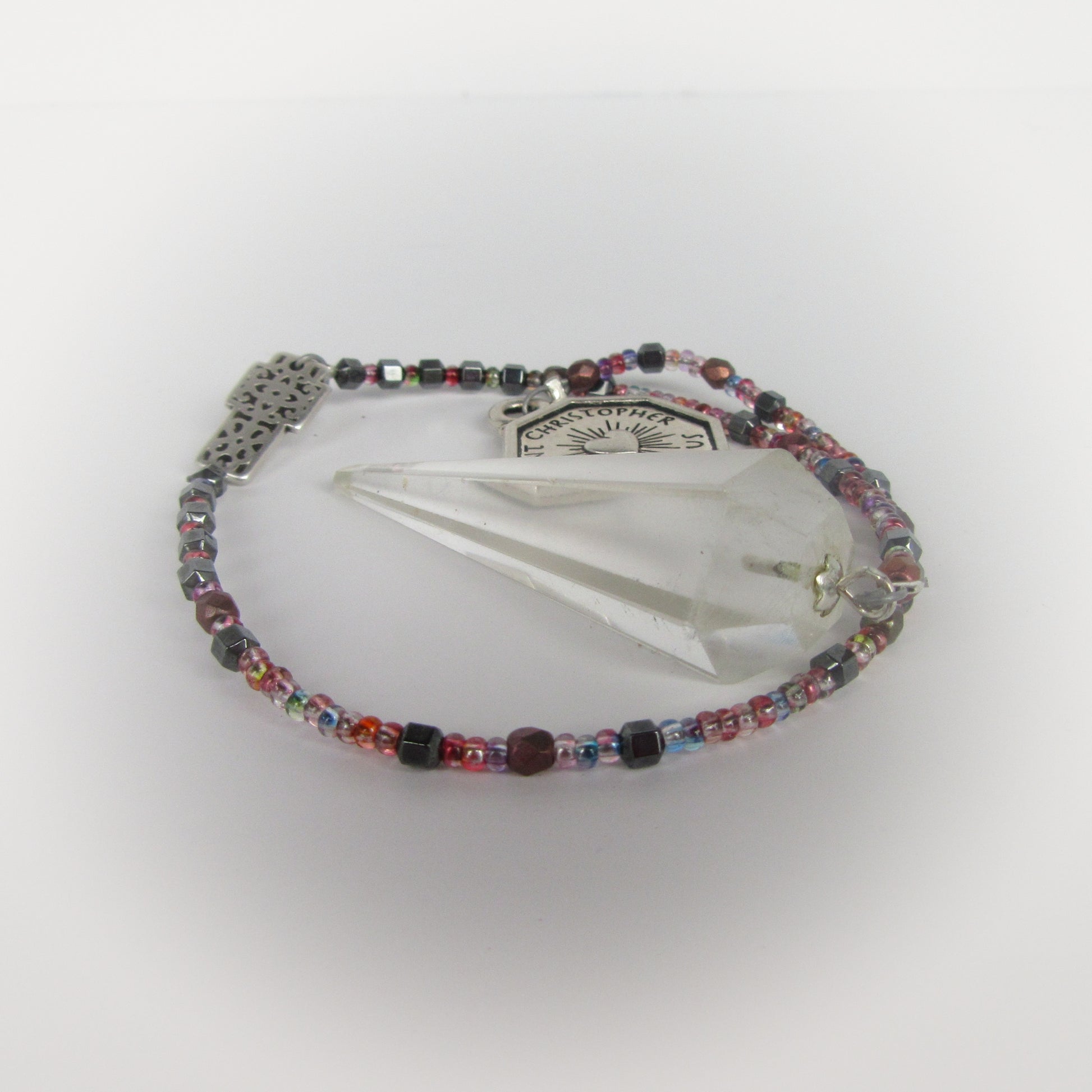 Multicolored beaded pendulum with a crystal on a white background