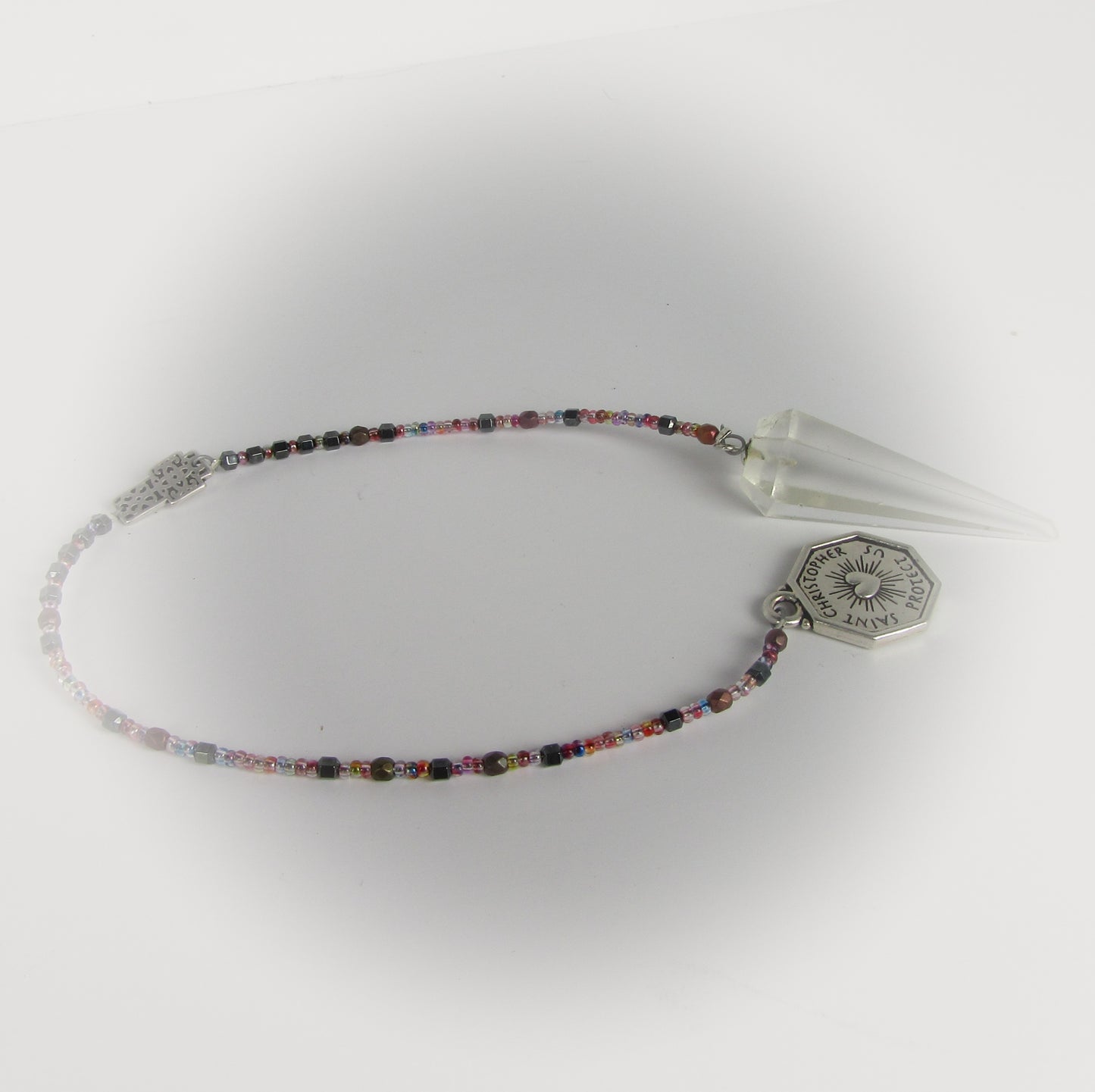 Multicolored beaded pendulum with a silver cross pendant on a white background