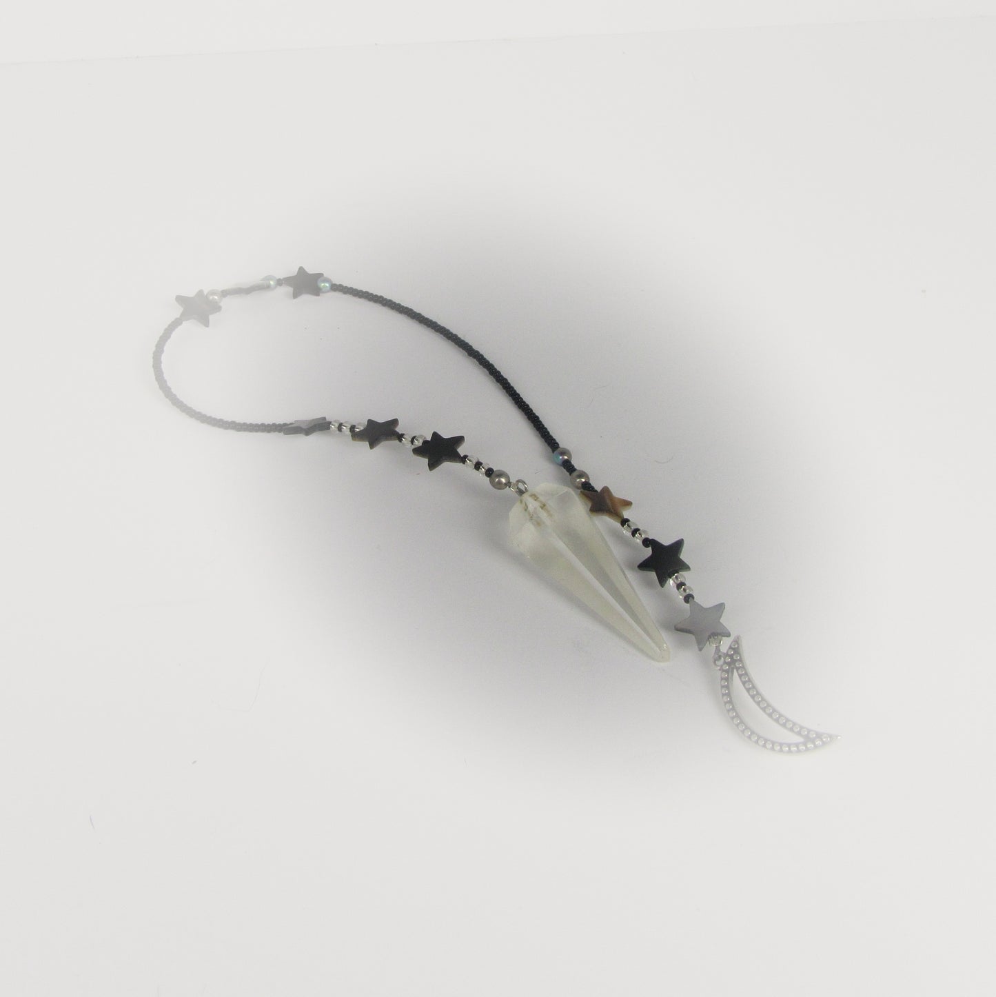 Star-shaped prndulum with a clear crystal on a white background