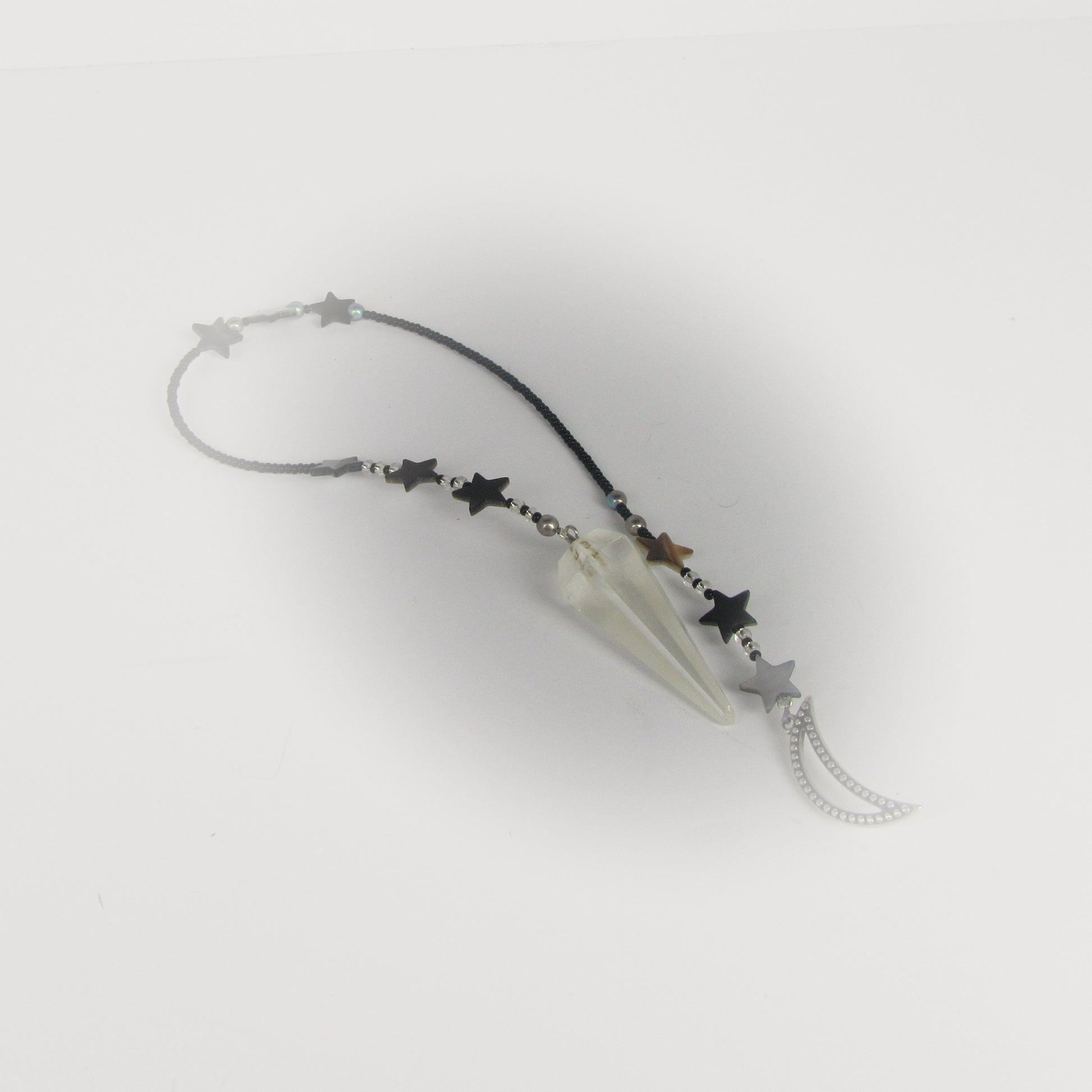 Star-shaped prndulum with a clear crystal on a white background