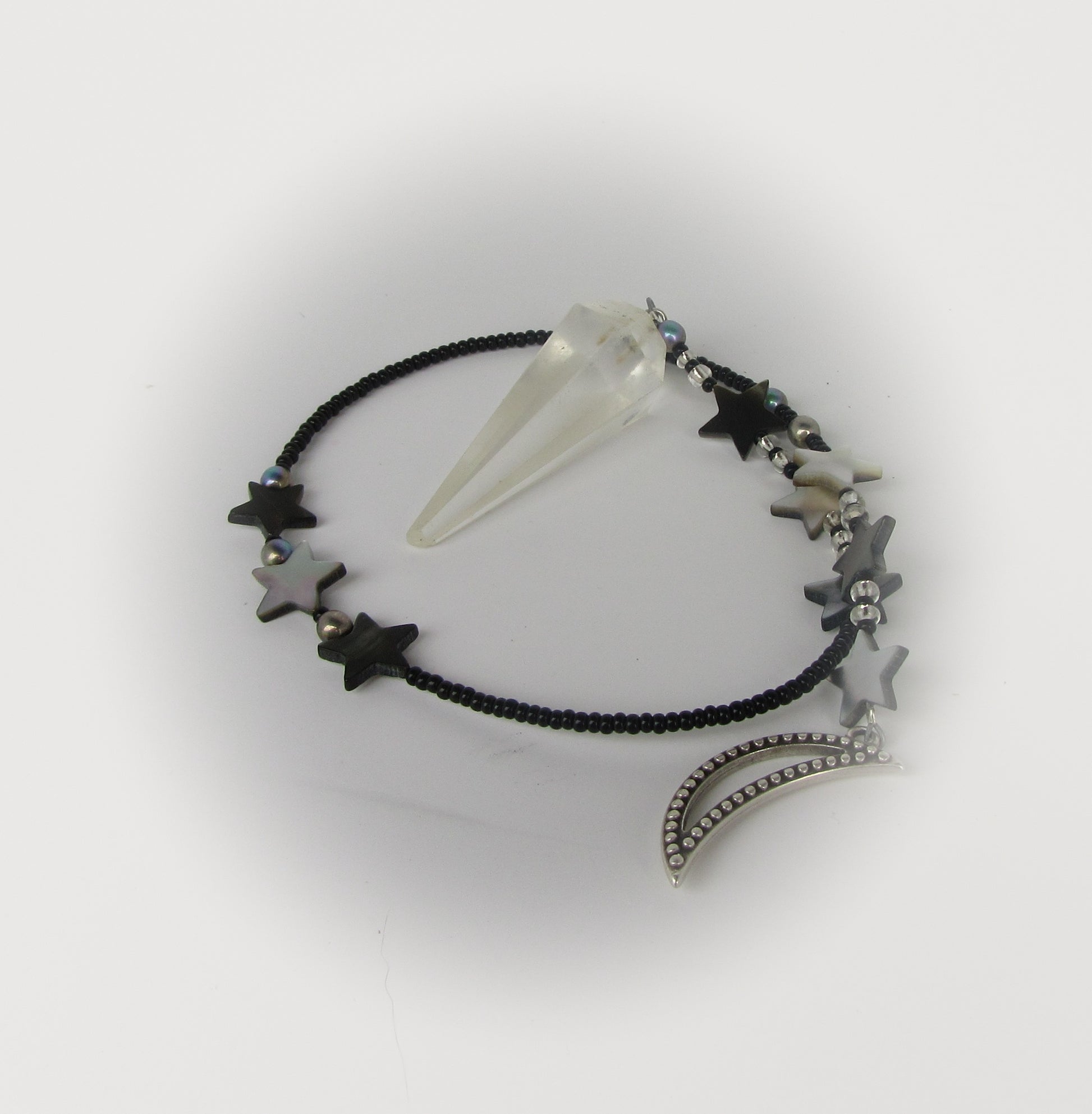 Pendulum with star-shaped beads and a clear crystal on a white background