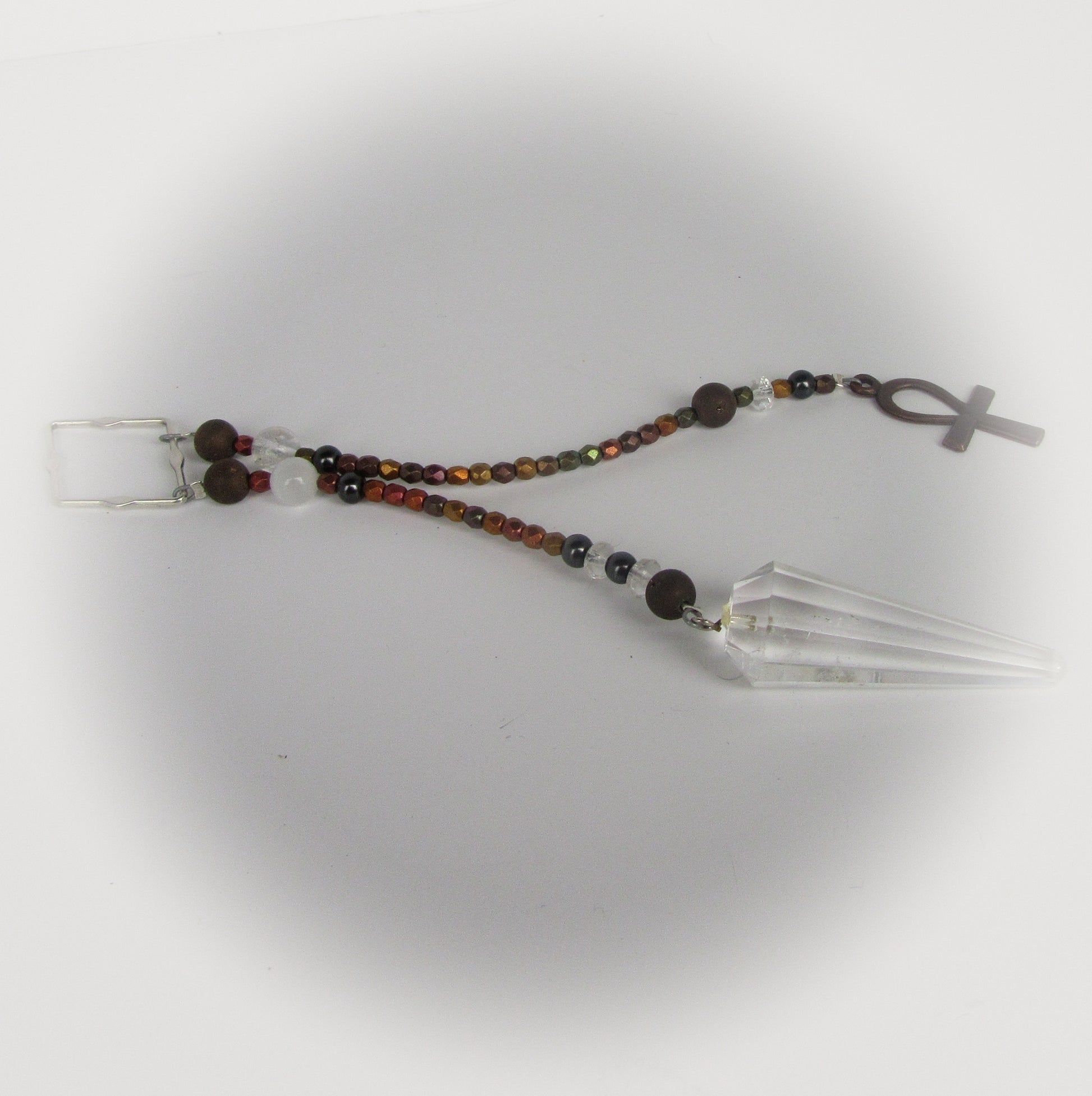 Beaded pendulum with an ankh charm on a white background
