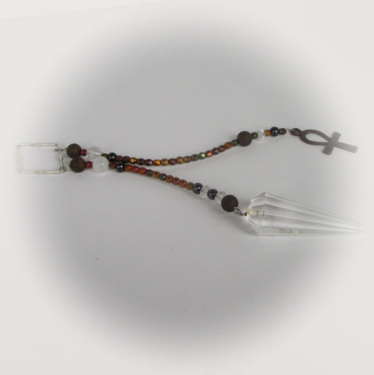 Beaded pendulum with an ankh charm on a white background
