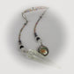 Pendulum with beads and a clear crystal on a white background