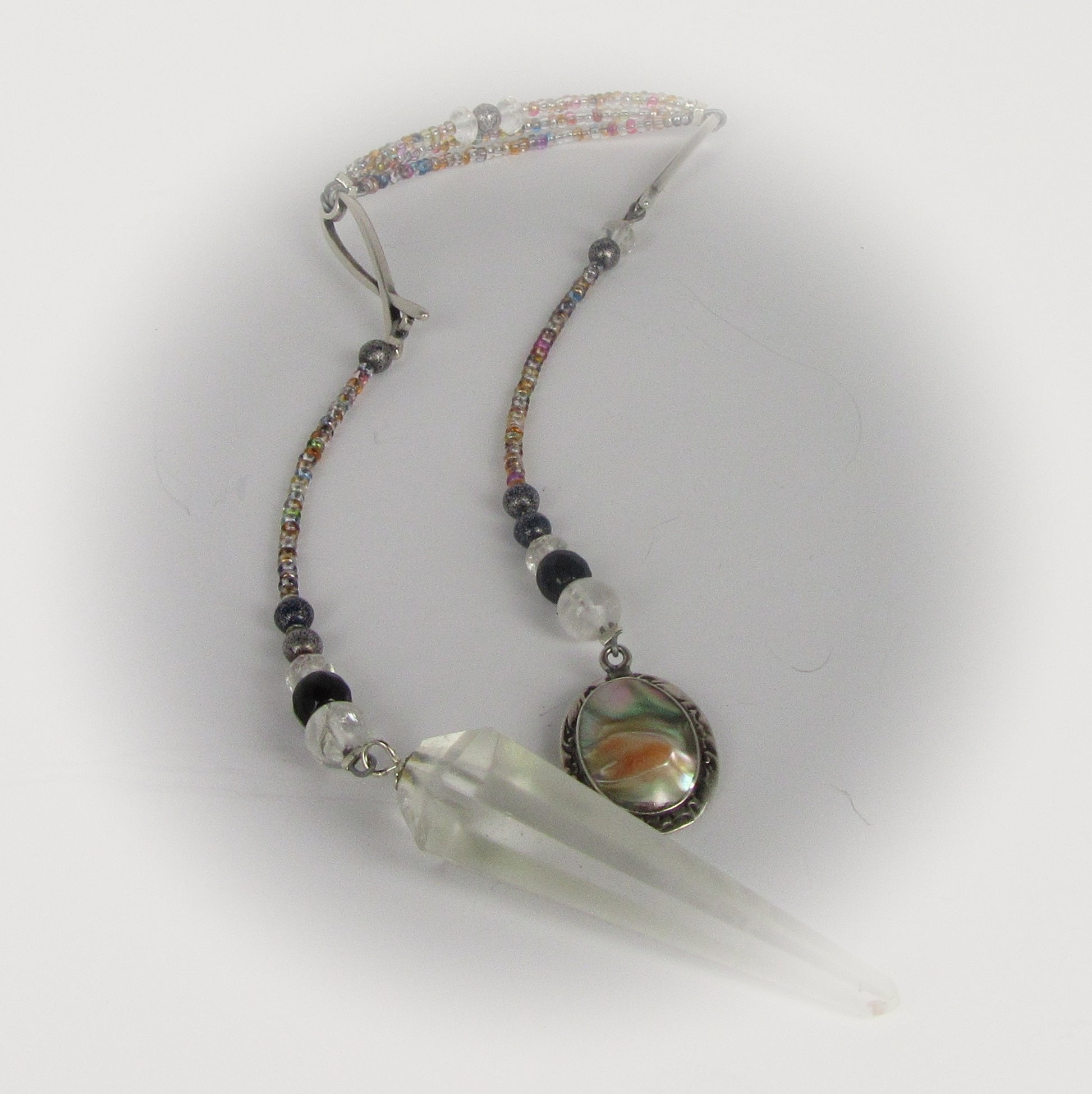 Pendulum with beads and a clear crystal on a white background