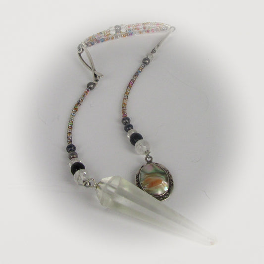 Pendulum with beads and a clear crystal on a white background