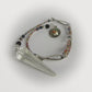 Crystal point with beaded pendulum on a white background