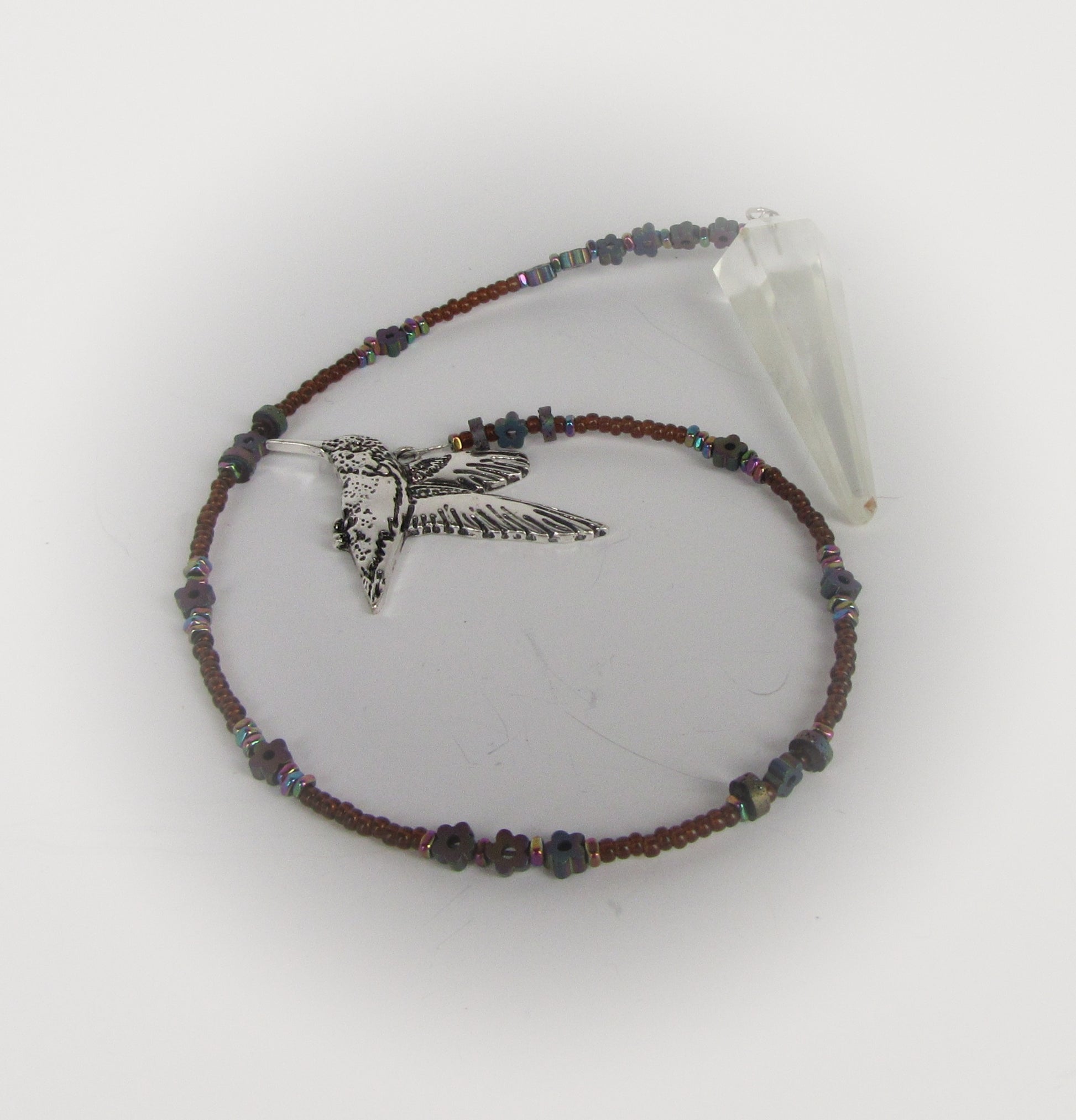 Beaded pendulum with a hummingbird charm on a white background
