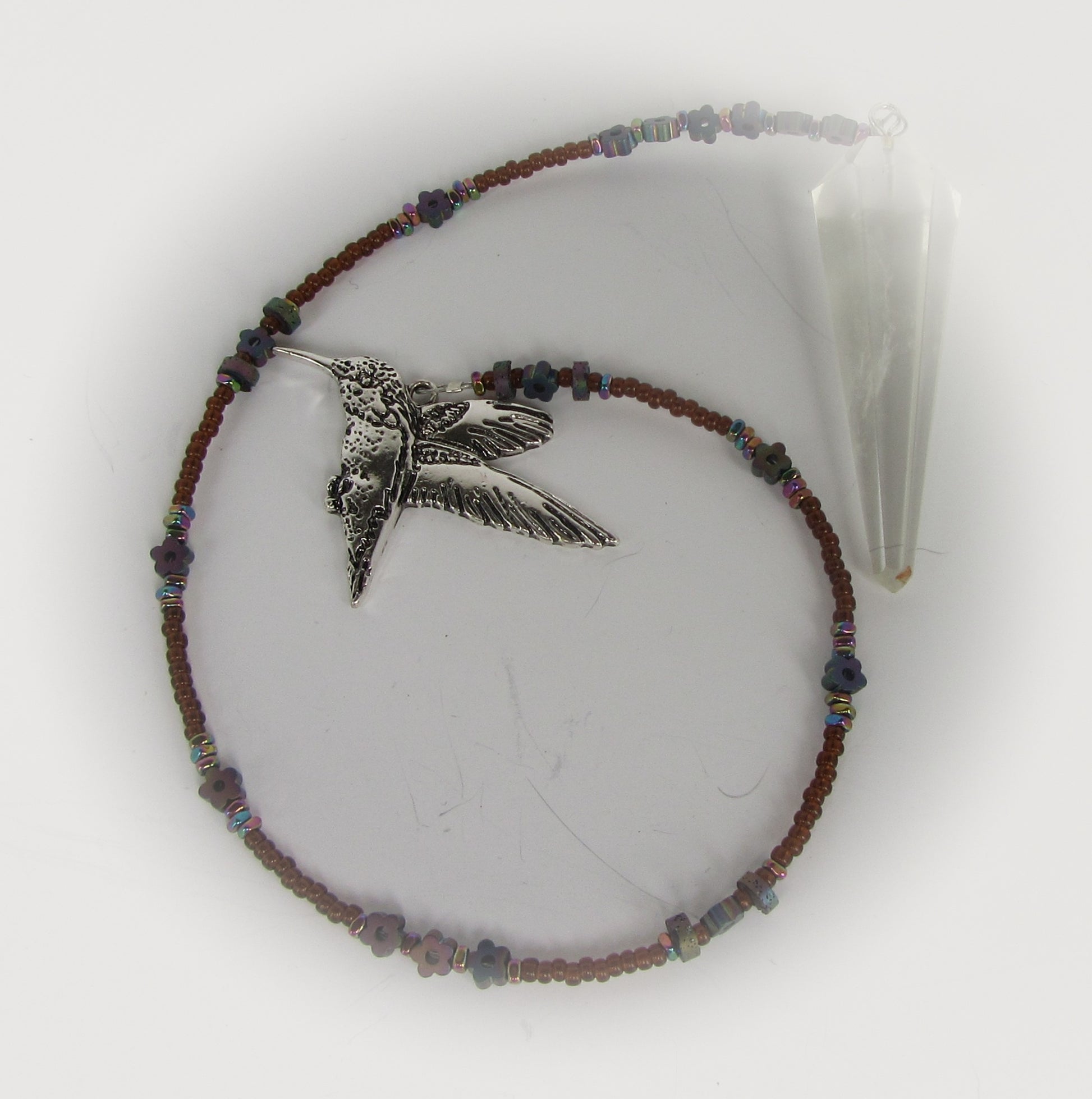Pendulum with a hummingbird charm and beaded design on a white background