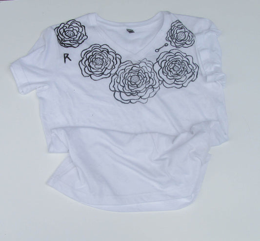 White t-shirt with black floral designs on a white background
