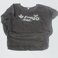 Gray t-shirt with white graphic design on a light gray background
