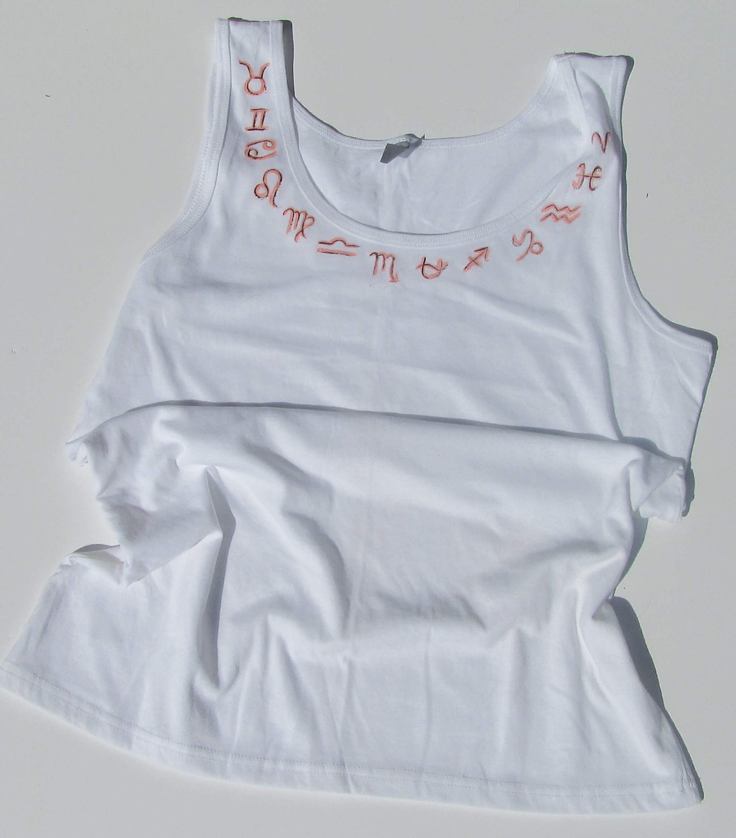 zodiac signs on a white tank top and white background
