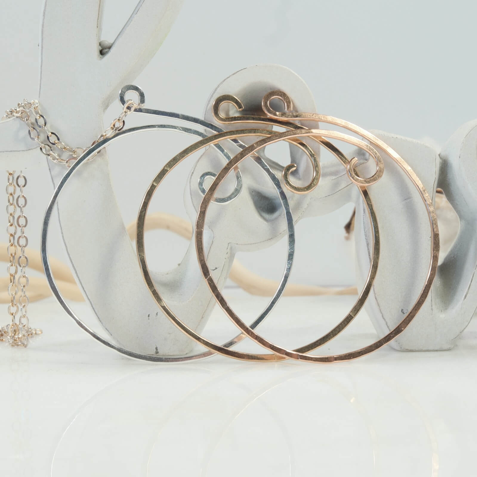 front view of gold hoop earrings on a white surface with a light background