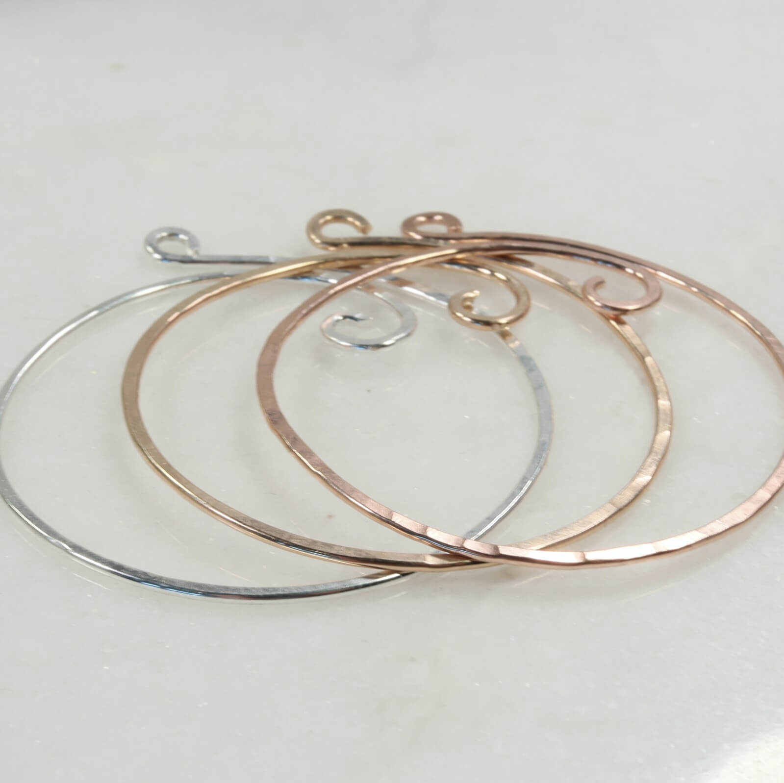 charm holder necklace in silver, rose gold, and gold on a light gray background